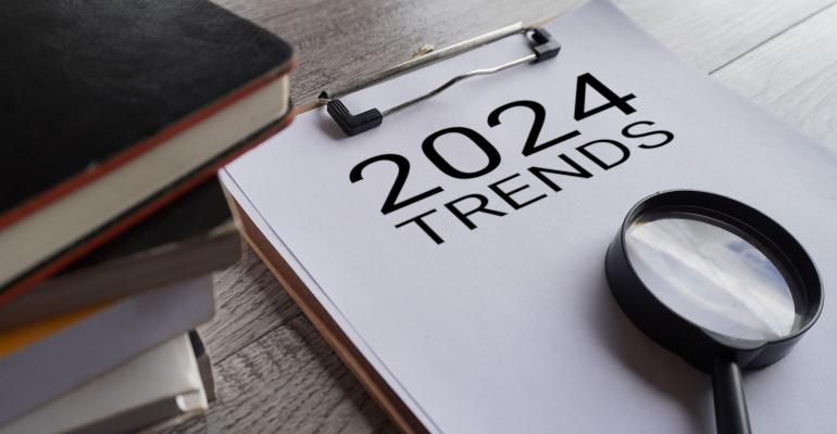2024 trends and magnifying glass on pad of paper