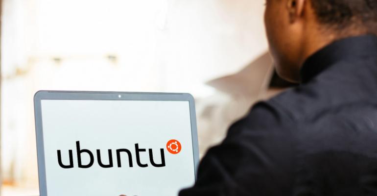 man working on a laptop with Ubuntu logo on its screen