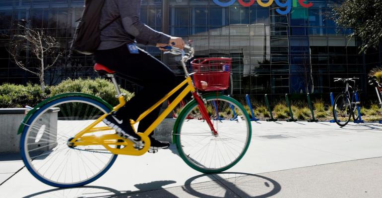 An emplyee passes the Google Inc. offices in Mountain View, California. Photographer: Michael Short/Bloomberg