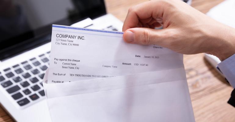 employee taking paystub out of an envelope