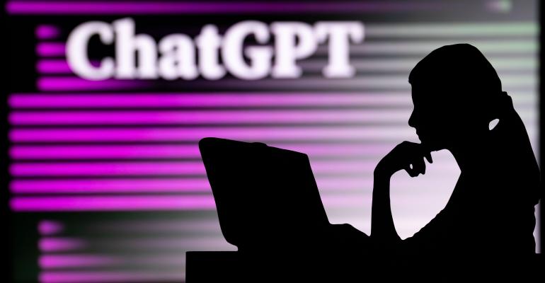 person's silhouette against a glowing wall that says ChatGPT