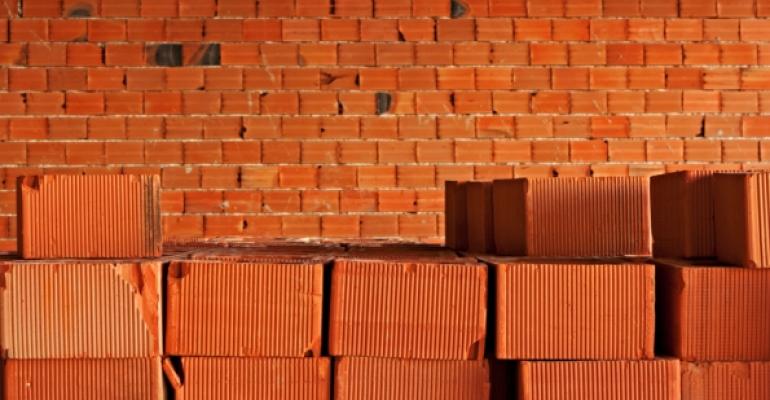 red bricks stacked in front of incomplete brick wall