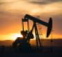 A pumpjack at an oil drilling site at sunset