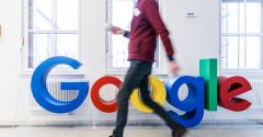 man walking past google logo
