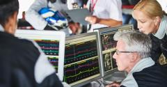 Formula one team reviewing diagnostics telemetry data on computers